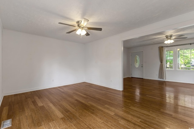 spare room with ceiling fan, wood finished floors, and baseboards