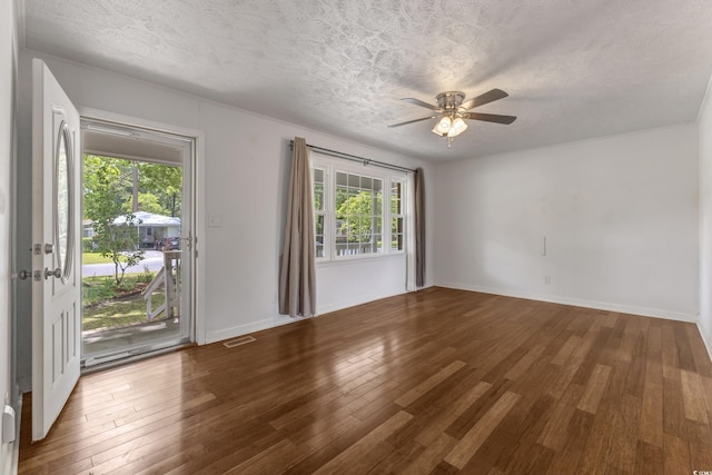 spare room with wood finished floors, ceiling fan, a textured ceiling, and baseboards