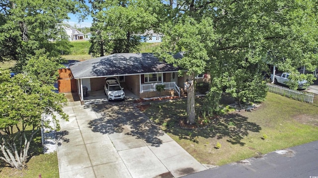 view of front facade featuring concrete driveway, covered porch, and an attached carport