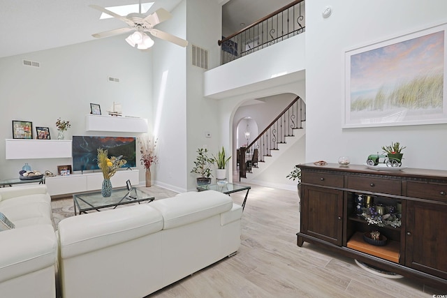 867 Cardinal Pl, North Myrtle Beach, SC 29582 - living room with a high ceiling, arched walkways, a ceiling fan, stairs, and light wood-type flooring