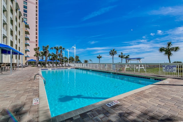 community pool featuring fence and a patio area