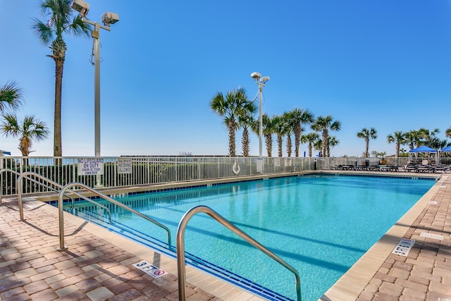 community pool with fence and a patio