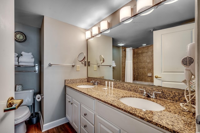 full bathroom featuring toilet, curtained shower, wood finished floors, double vanity, and baseboards