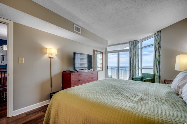 bedroom featuring dark wood-style flooring, access to exterior, baseboards, and a textured ceiling