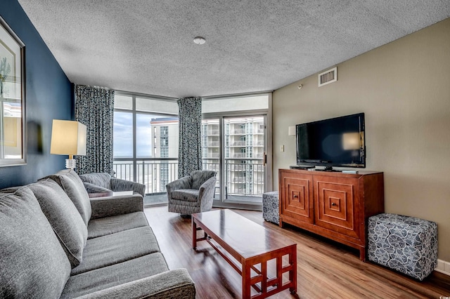 living room with floor to ceiling windows, a textured ceiling, and wood finished floors