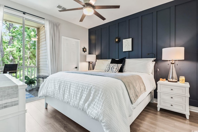 bedroom featuring access to outside, wood finished floors, a ceiling fan, and baseboards