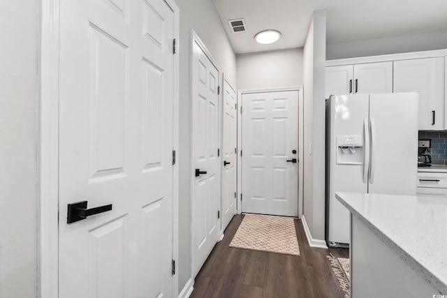 doorway featuring dark wood-type flooring and baseboards