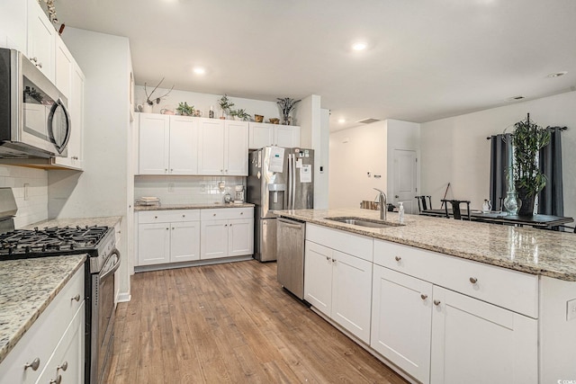2059 Borgata Loop, Longs, SC 29568 - kitchen with appliances with stainless steel finishes, a sink, backsplash, light wood-type flooring, and white cabinets