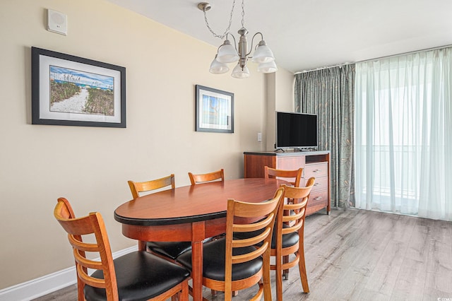 201 S Ocean Blvd Unit 1112, Myrtle Beach, SC 29577 - dining area with light wood-style flooring, a chandelier, and baseboards