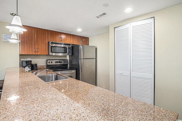 201 S Ocean Blvd Unit 1112, Myrtle Beach, SC 29577 - kitchen featuring stainless steel appliances, brown cabinets, a sink, recessed lighting, and pendant lighting