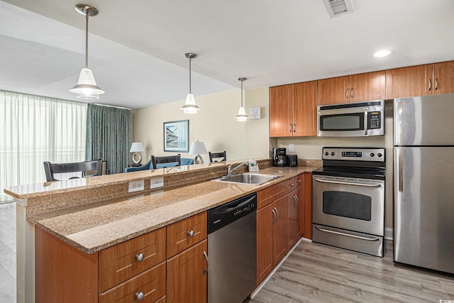 201 S Ocean Blvd Unit 1112, Myrtle Beach, SC 29577 - kitchen featuring stainless steel appliances, a sink, a peninsula, light wood-type flooring, and brown cabinets