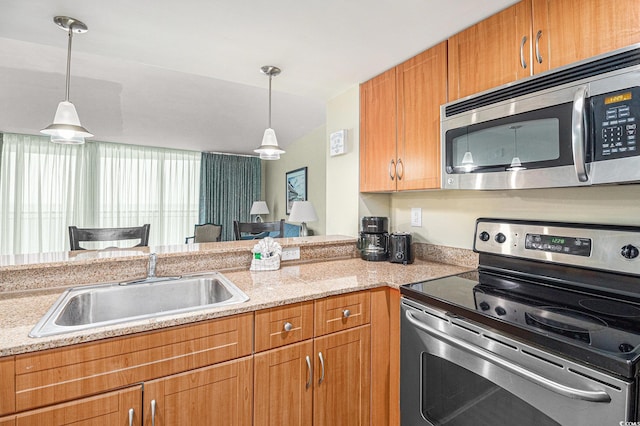 201 S Ocean Blvd Unit 1112, Myrtle Beach, SC 29577 - kitchen with appliances with stainless steel finishes, decorative light fixtures, a sink, brown cabinetry, and a peninsula