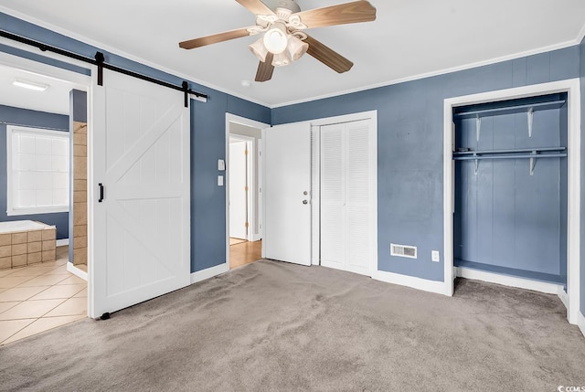 3001 Wiley Dr, North Myrtle Beach, SC 29582 - unfurnished bedroom with two closets, baseboards, a barn door, ornamental molding, and carpet flooring
