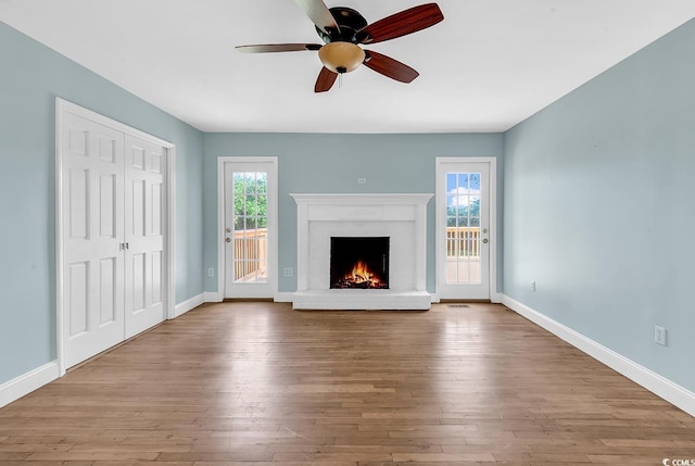 3001 Wiley Dr, North Myrtle Beach, SC 29582 - unfurnished living room featuring a lit fireplace, baseboards, hardwood / wood-style floors, and ceiling fan