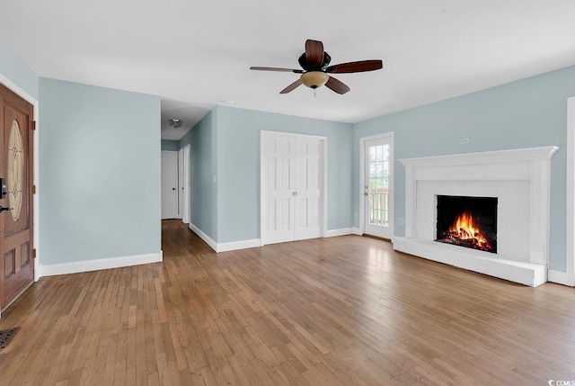 3001 Wiley Dr, North Myrtle Beach, SC 29582 - unfurnished living room featuring hardwood / wood-style flooring, ceiling fan, baseboards, and a brick fireplace