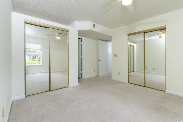 8925 Duckview Dr Unit A, Surfside Beach, SC 29575 - unfurnished bedroom with multiple closets, carpet floors, a textured ceiling, a ceiling fan, and baseboards