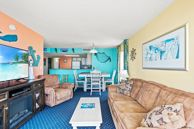 living room featuring carpet and a textured ceiling