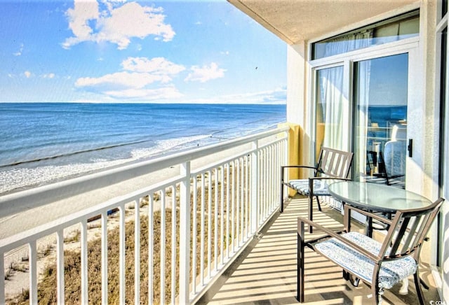 balcony with view of water and beach