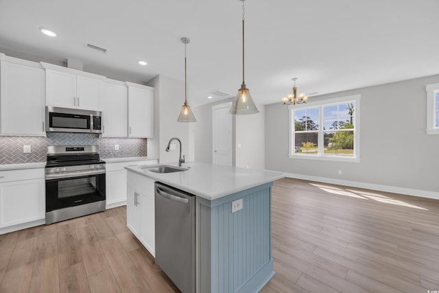 1929 Indigo Cove Ln, Calabash, NC 28467 - kitchen featuring appliances with stainless steel finishes, a sink, light wood finished floors, backsplash, and light countertops