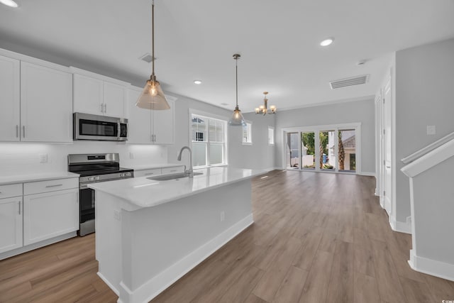 1961 Indigo Cove Ln, Calabash, NC 28467 - kitchen with appliances with stainless steel finishes, a sink, white cabinets, a chandelier, and recessed lighting