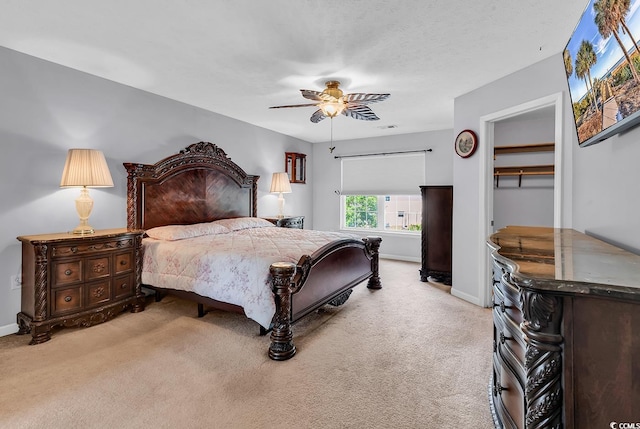 bedroom featuring light colored carpet, baseboards, and a ceiling fan
