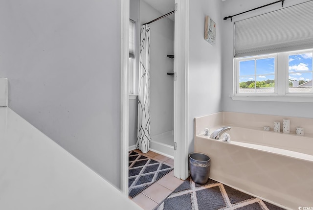 full bathroom featuring a shower stall, a garden tub, and tile patterned flooring