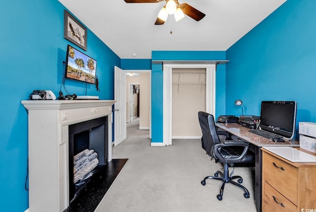 office area with ceiling fan, light colored carpet, and baseboards