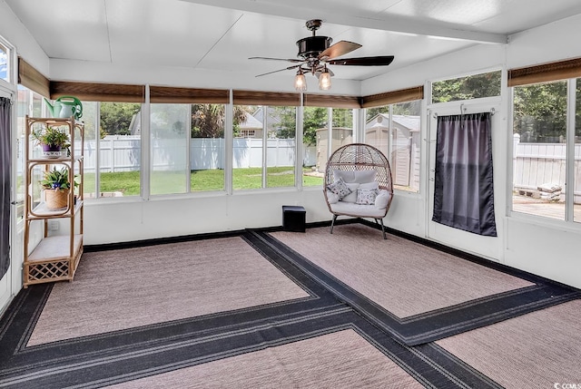unfurnished sunroom featuring ceiling fan