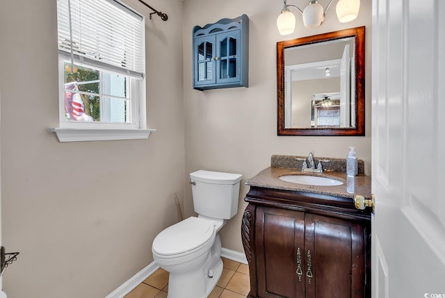 bathroom with tile patterned flooring, baseboards, toilet, and vanity