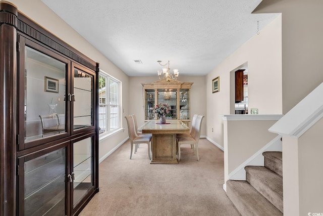 dining area with a chandelier, carpet floors, baseboards, stairs, and a textured ceiling