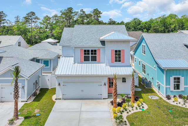 view of front of property featuring driveway, board and batten siding, metal roof, and an attached garage