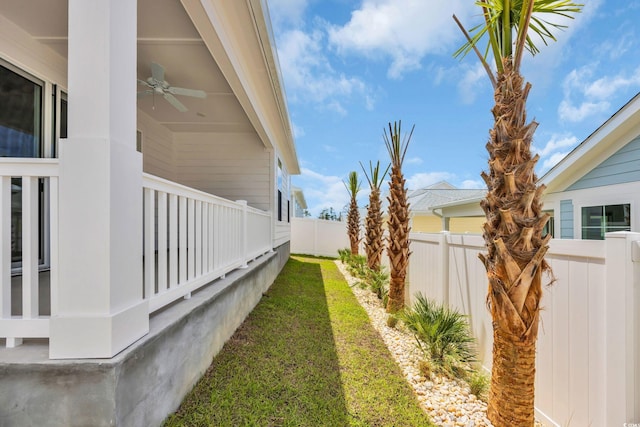fenced backyard featuring ceiling fan