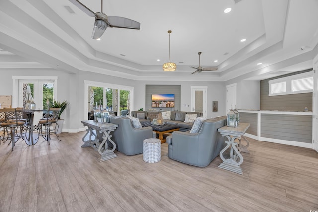 living room featuring ceiling fan, a tray ceiling, french doors, wood finished floors, and recessed lighting