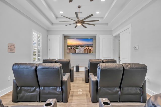 home theater room with a ceiling fan, recessed lighting, a raised ceiling, light wood-style floors, and baseboards