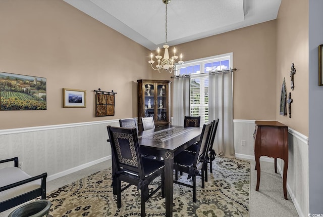 dining room featuring a chandelier, a wainscoted wall, and carpet flooring
