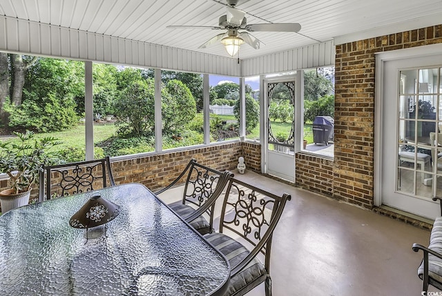 sunroom / solarium with a ceiling fan and outdoor dining space