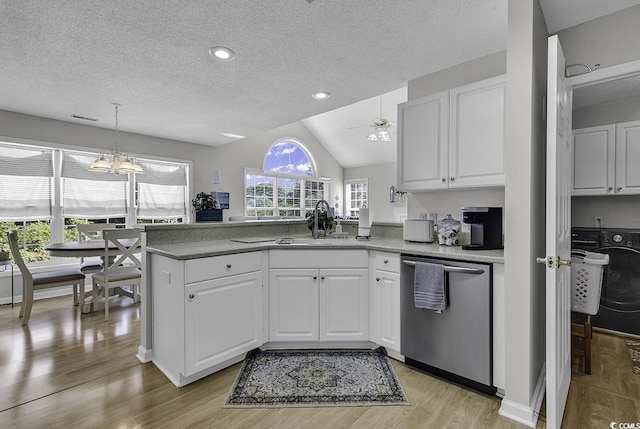 kitchen featuring dishwasher, a textured ceiling, a peninsula, a sink, and white cabinetry