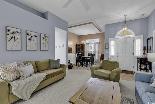 carpeted living area featuring a chandelier and ceiling fan
