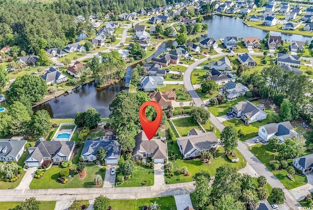 aerial view of property and surrounding area featuring nearby suburban area and a nearby body of water
