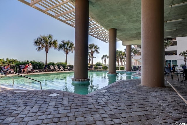 community pool with a pergola and a patio area