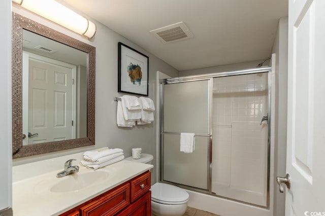 full bath with a shower with door, toilet, and vanity