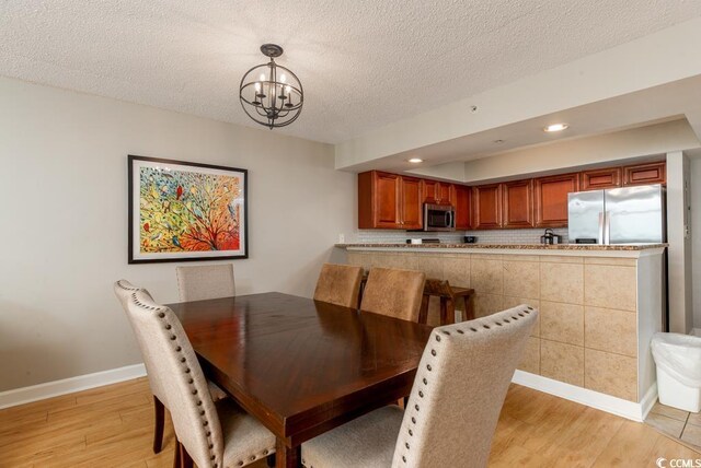 1903 S Ocean Blvd S Unit 808, North Myrtle Beach, SC 29582 - dining room featuring light wood-style floors, a chandelier, baseboards, a textured ceiling, and recessed lighting