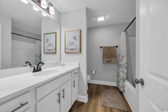 full bathroom with toilet, wood finished floors, vanity, baseboards, and shower / bath combination with curtain