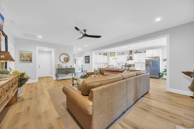 living room with ceiling fan, light wood finished floors, baseboards, and recessed lighting