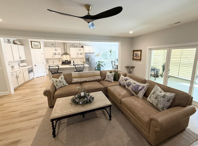 living room with ceiling fan, light wood-style flooring, and recessed lighting