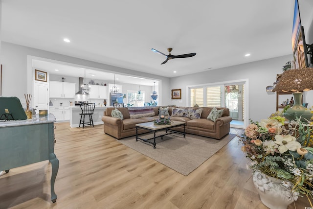 living area with a ceiling fan, light wood-style floors, and recessed lighting