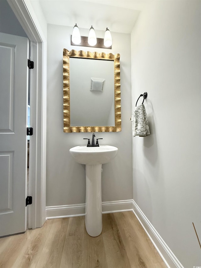 bathroom with wood finished floors and baseboards