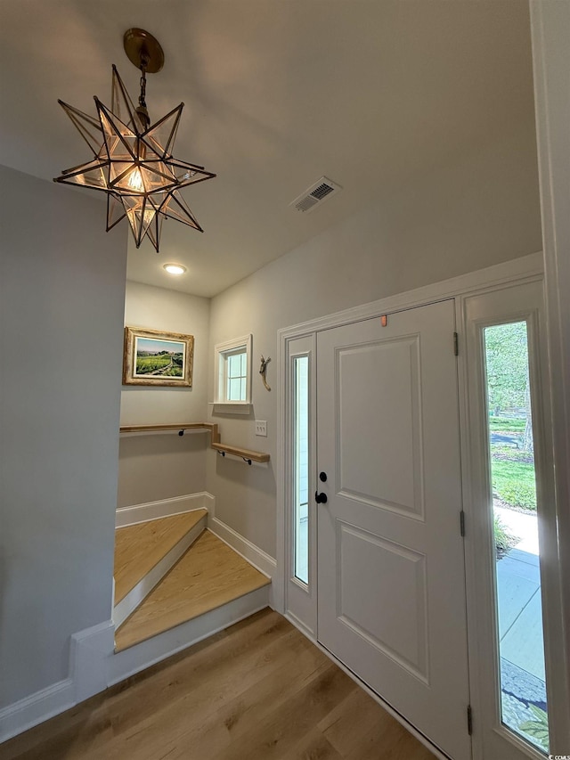 foyer with wood finished floors, a chandelier, baseboards, and recessed lighting