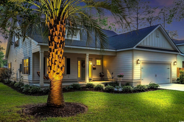 view of front of home featuring a yard, a porch, a garage, and board and batten siding