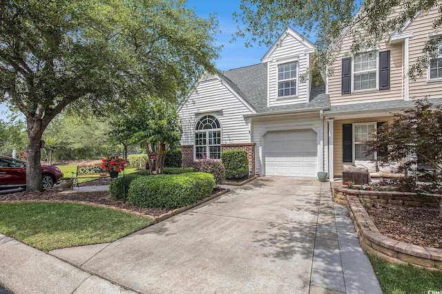 view of front of property with a garage, brick siding, a shingled roof, and driveway